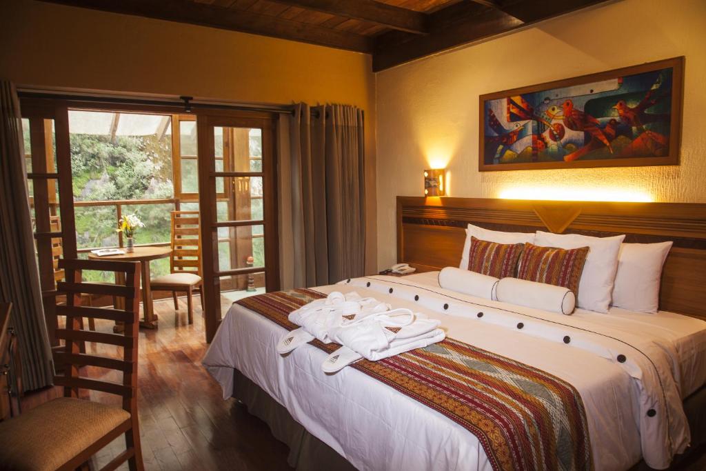 马丘比丘卡萨得索尔麦池皮池酒店的一间卧室配有一张大床和毛巾