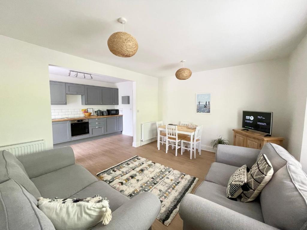 托基Lincombe Court Apartment Wellswood Torquay的一间带两张沙发的客厅和一间厨房