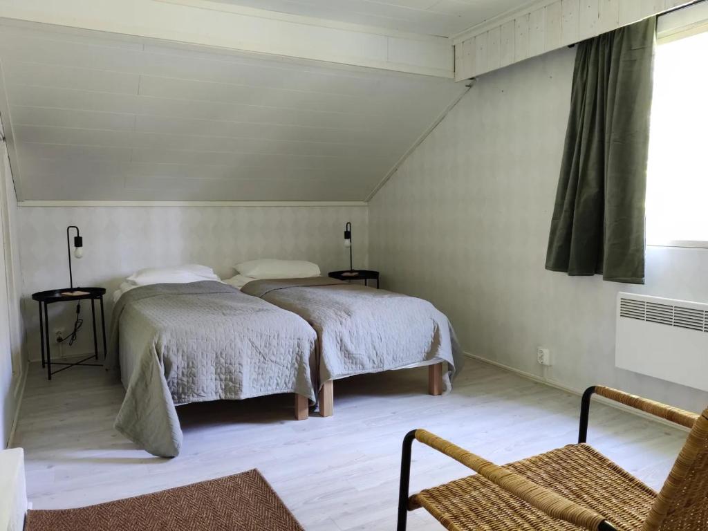 拉彭兰塔Cozy cottage in Pontus的一间卧室配有两张床和椅子