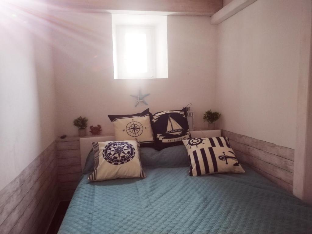 丽都迪奥斯蒂亚Lungomare Toscanelli 206 room fronte mare的卧室配有带枕头的床铺和窗户。