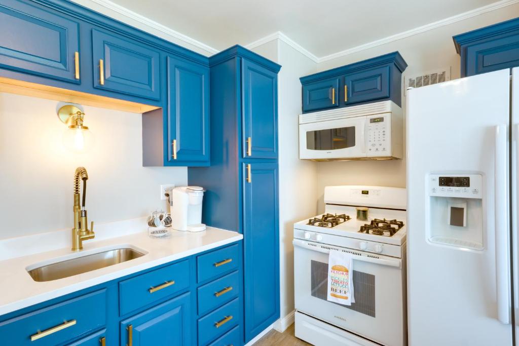 密尔沃基Milwaukee Home with Serene Patio and Backyard Garden!的厨房配有蓝色橱柜和白色冰箱