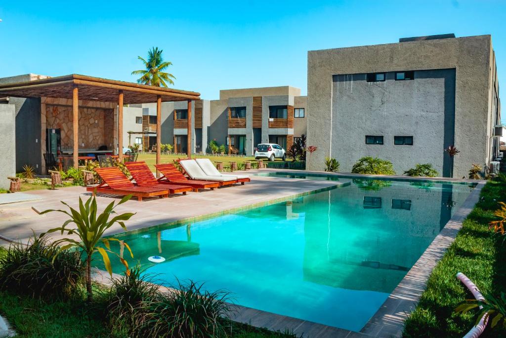 佩德拉斯港Villa Patacho Nature Apartamento 103 C的一座带躺椅的游泳池位于大楼旁