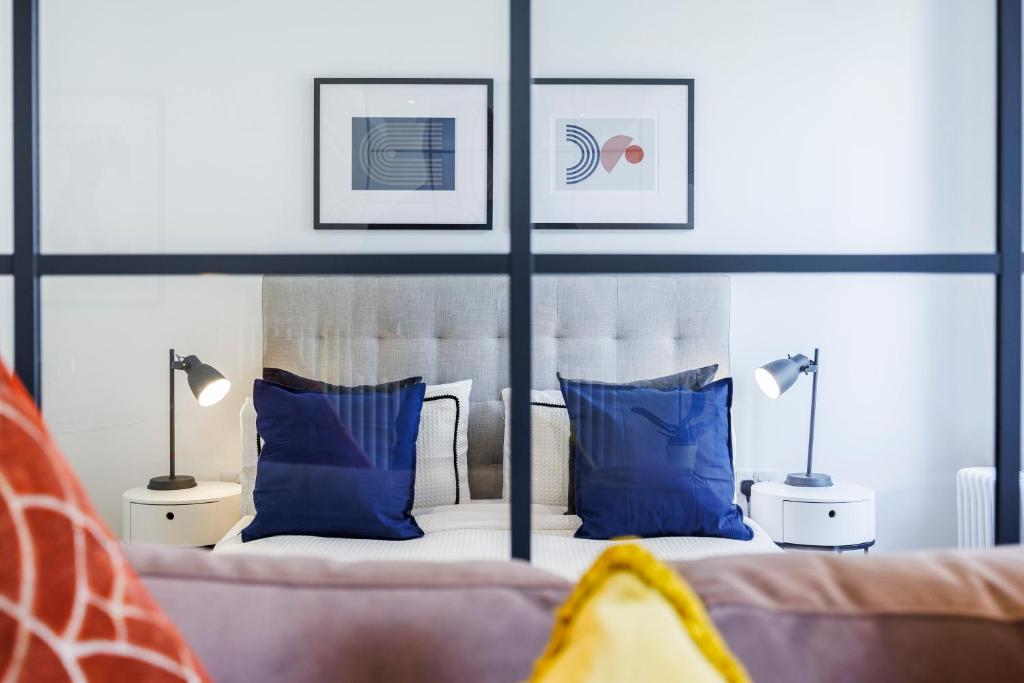 伦敦Apartment Near Canary Wharf 02 Arena & Excel的一间卧室配有两张带蓝色枕头的床