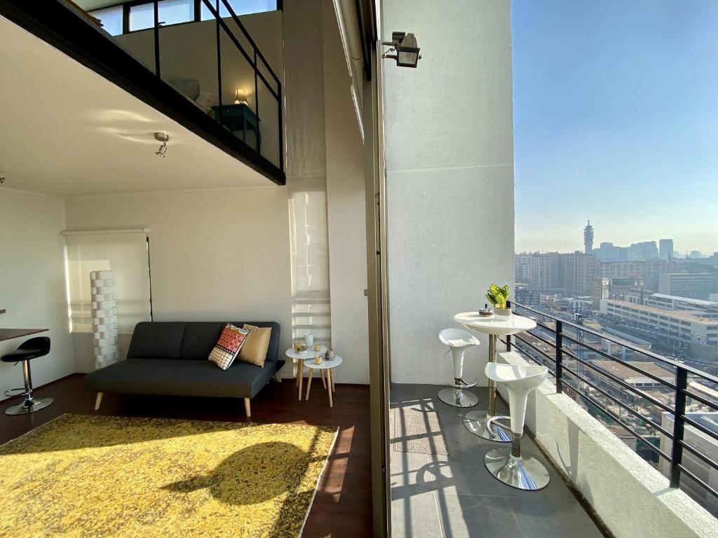圣地亚哥Loft Smart Panoramico - Santiago的带沙发的客厅和阳台