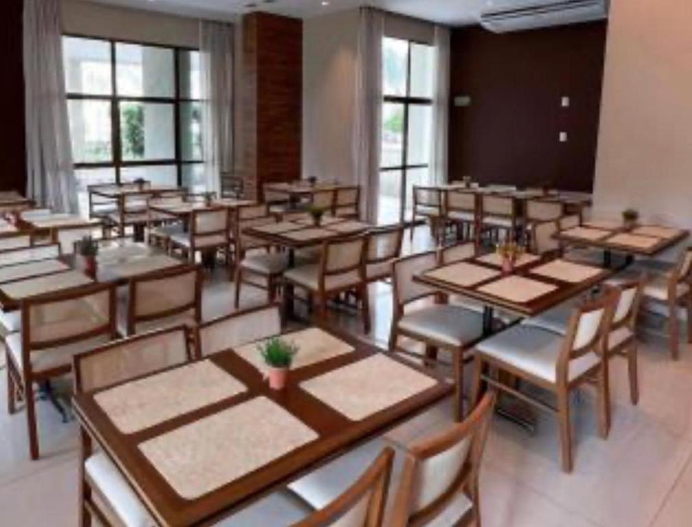 里约热内卢Flat Hotel Samba Barra Jeunesse Arena Projac Rio Centro的用餐室设有桌椅和窗户。