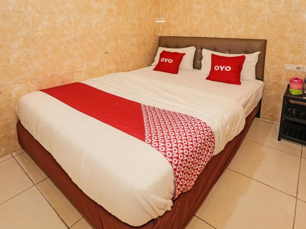 South TangerangSUPER OYO 92672 Hotel Bsd的床上有两个红色枕头的床