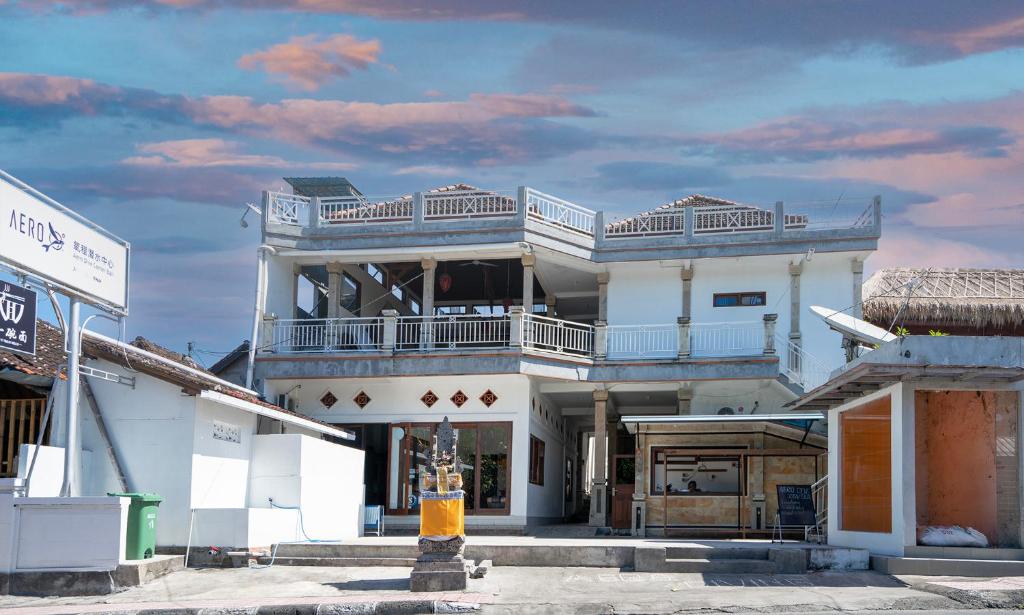 图兰奔AERO氧程巴厘岛潜水度假酒店的街道上一座大型白色建筑,设有阳台