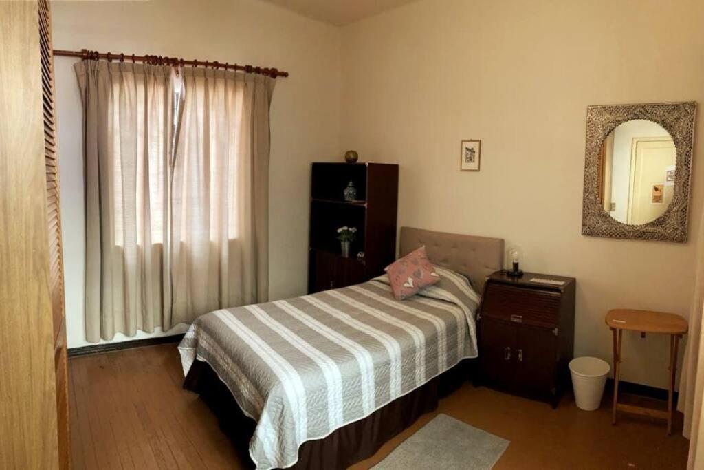 墨西哥城Habitación con terraza privada的一间卧室配有一张床、镜子和窗户