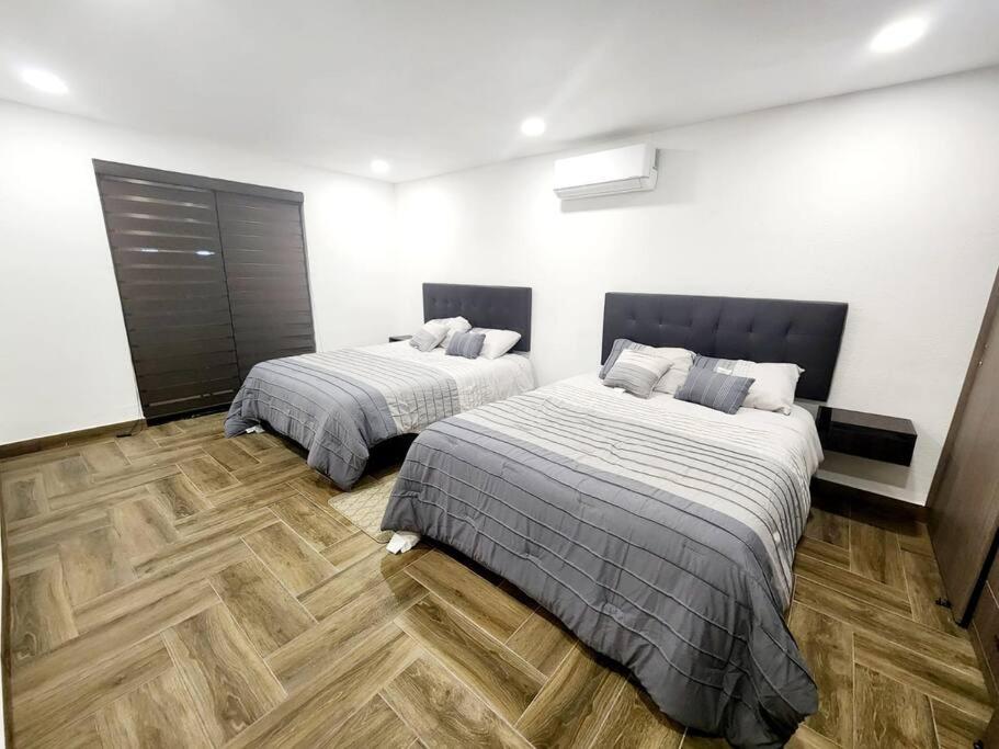 华雷斯城Departamento Pitagoras No 3的一间卧室设有两张床,铺有木地板