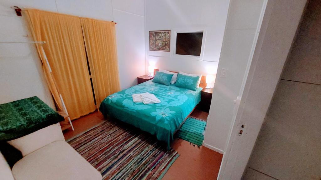 拉罗汤加Barefoot Base Tupapa的一间小卧室,配有一张床和一把椅子