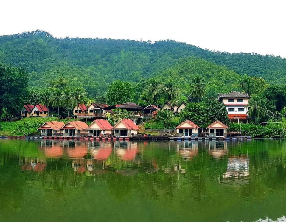 Tha KradanLake Hill Resort Kanchanaburi的水体岸边的一群房子