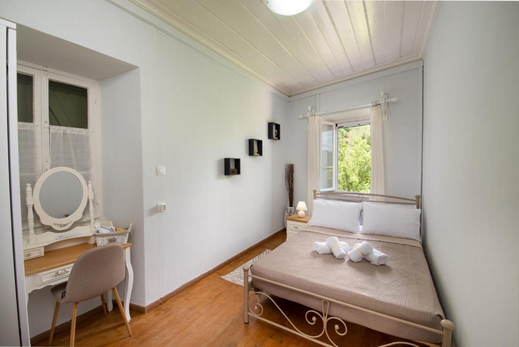 RantátikaChrysa's Hideaway的一间卧室配有一张床、一张书桌和一个窗户。