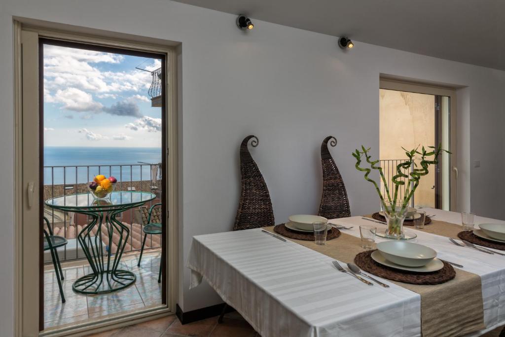陶尔米纳Giasone Apartments的一间设有桌子的海景用餐室