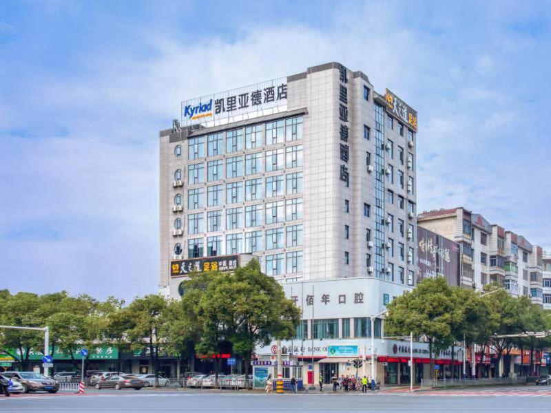 萍乡凯里亚德酒店(萍乡万龙湾店)的一座高大的白色建筑,上面有标志