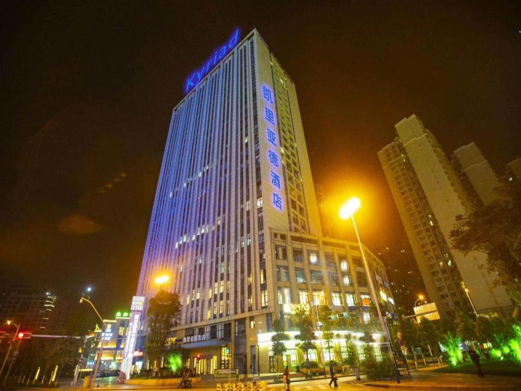昆明凯里亚德酒店(昆明高新区吾悦广场店)的一座高大的建筑,晚上有蓝色的灯光