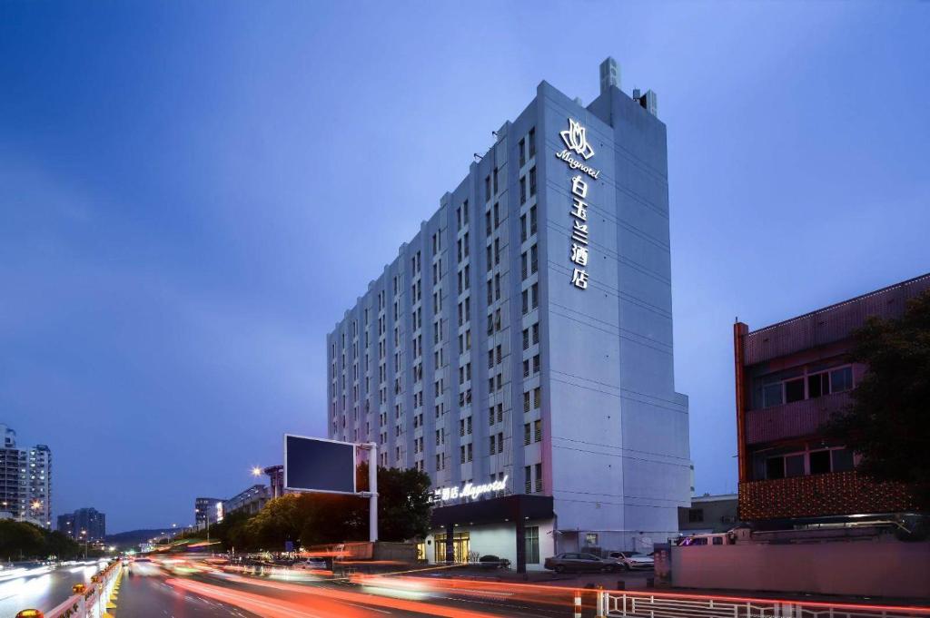 Jiangning白玉兰南京航空航天大学胜太西路酒店的一座高大的白色建筑,上面有时钟