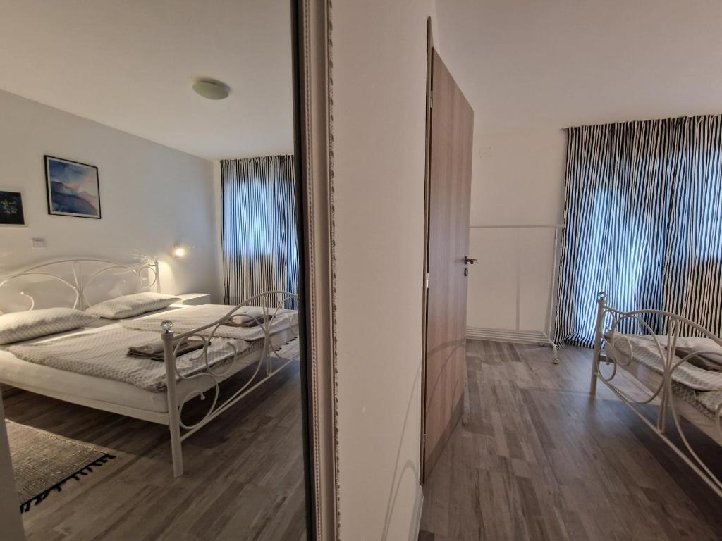 TušilovićApartman Castle的卧室的镜子反射,卧室内设有一张床