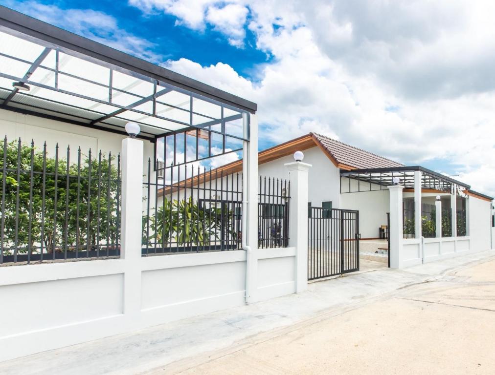 Ban Tao PunTonsoi Hathairat的白色的房子,设有门和栅栏