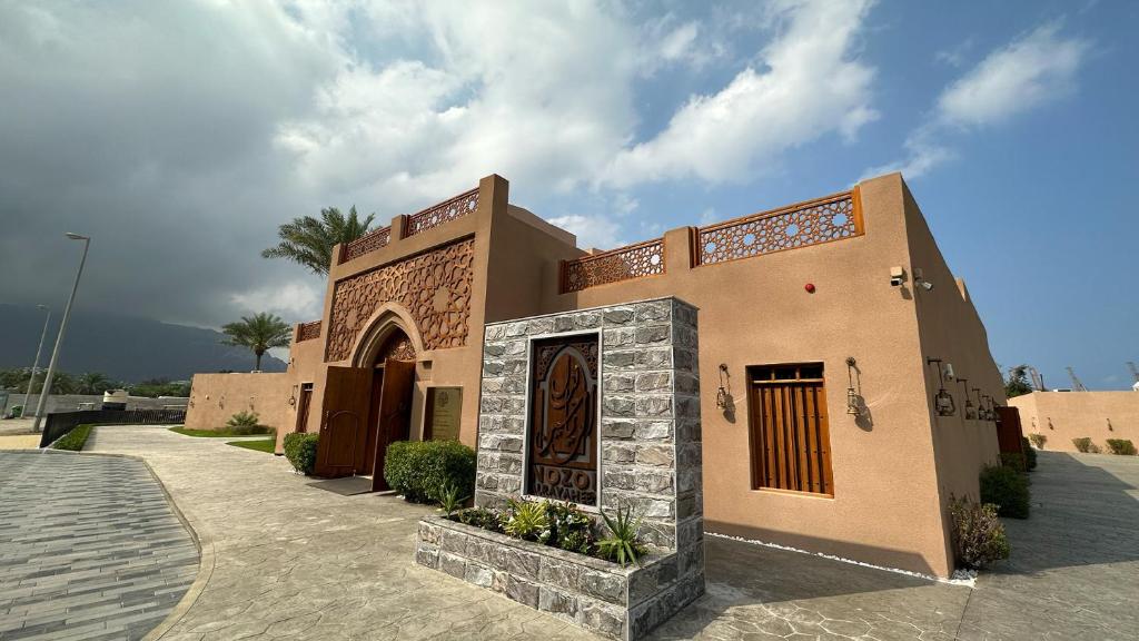 豪尔费坎Nozol Al Rayaheen By Sharjah Collection的建筑的一侧有门