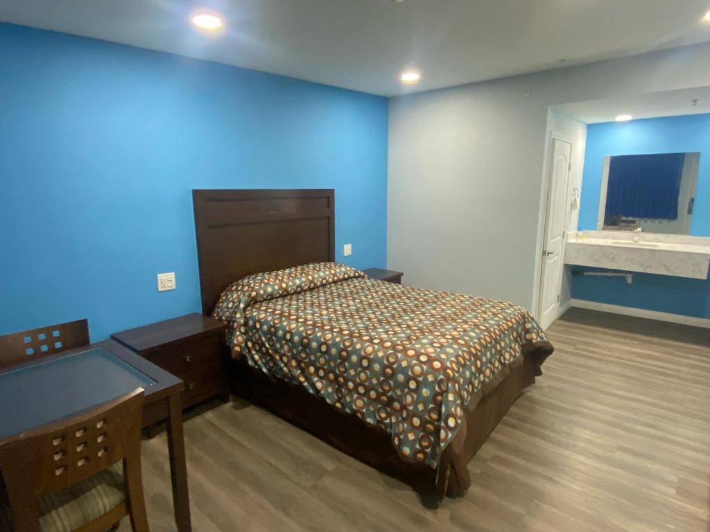 科斯塔梅萨Star Inn Motel的一间卧室配有一张床和一张书桌