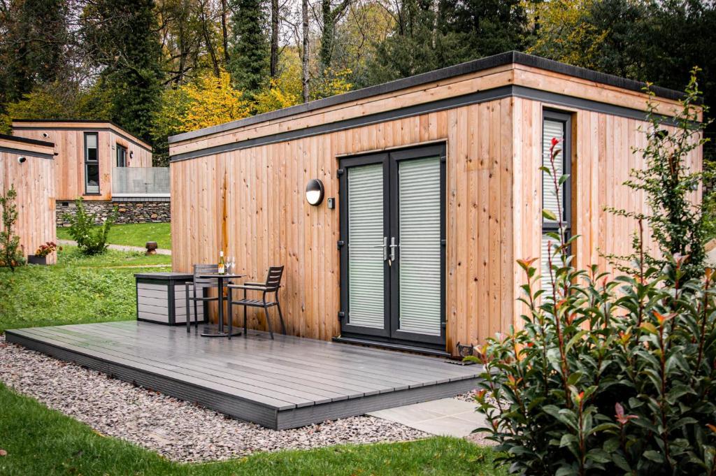WinsterComfy Lake District Cabins - Winster, Bowness-on-Windermere的小木屋,在院子里配有桌子和椅子