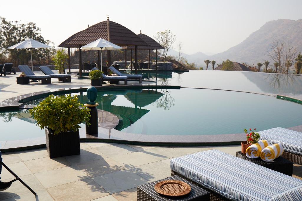 乌代浦The Ananta Udaipur的度假酒店内带桌椅的游泳池