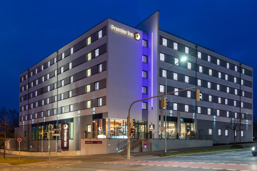 纽伦堡Premier Inn Nürnberg City Nordost的酒店大楼前方有紫色光