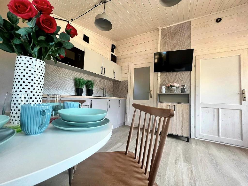 波别罗沃Domki - Sosnowy Las的厨房配有桌子和红玫瑰花瓶