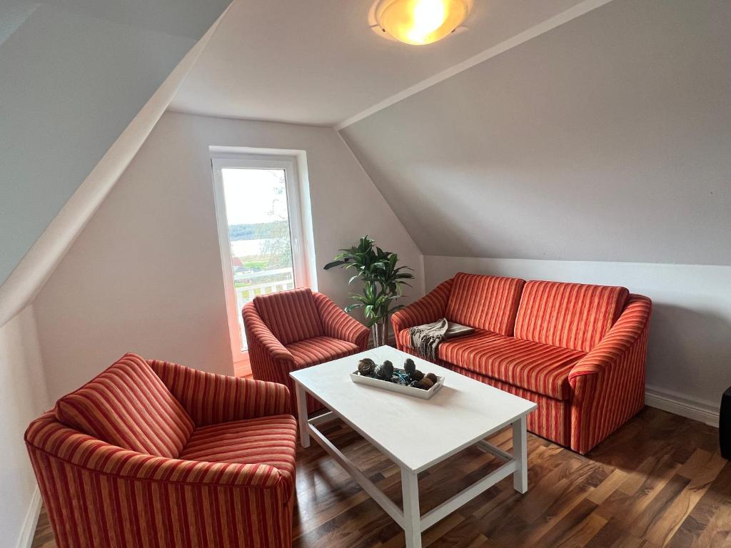 宾茨Haus Godewind的客厅配有两把椅子和一张桌子