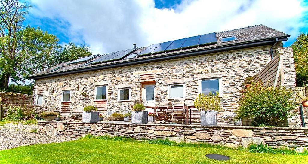 兰戈伦Cefn Ceiriog的屋顶上设有太阳能电池板的石头房子