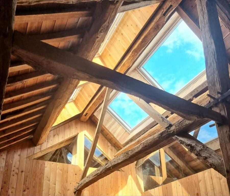 罗什福尔Cerf, ouvre-moi B&B的一座带窗户的木制建筑的屋顶