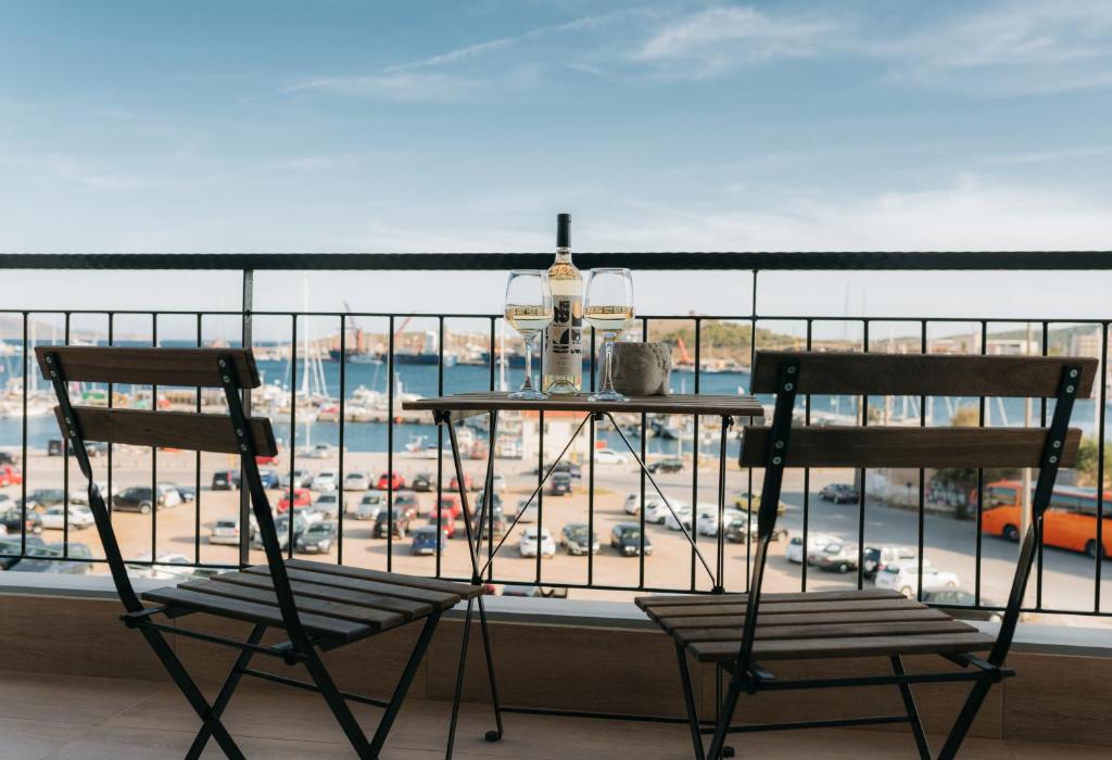 拉夫里翁Luxury Port View的阳台配有两把椅子,享有停车场的景致