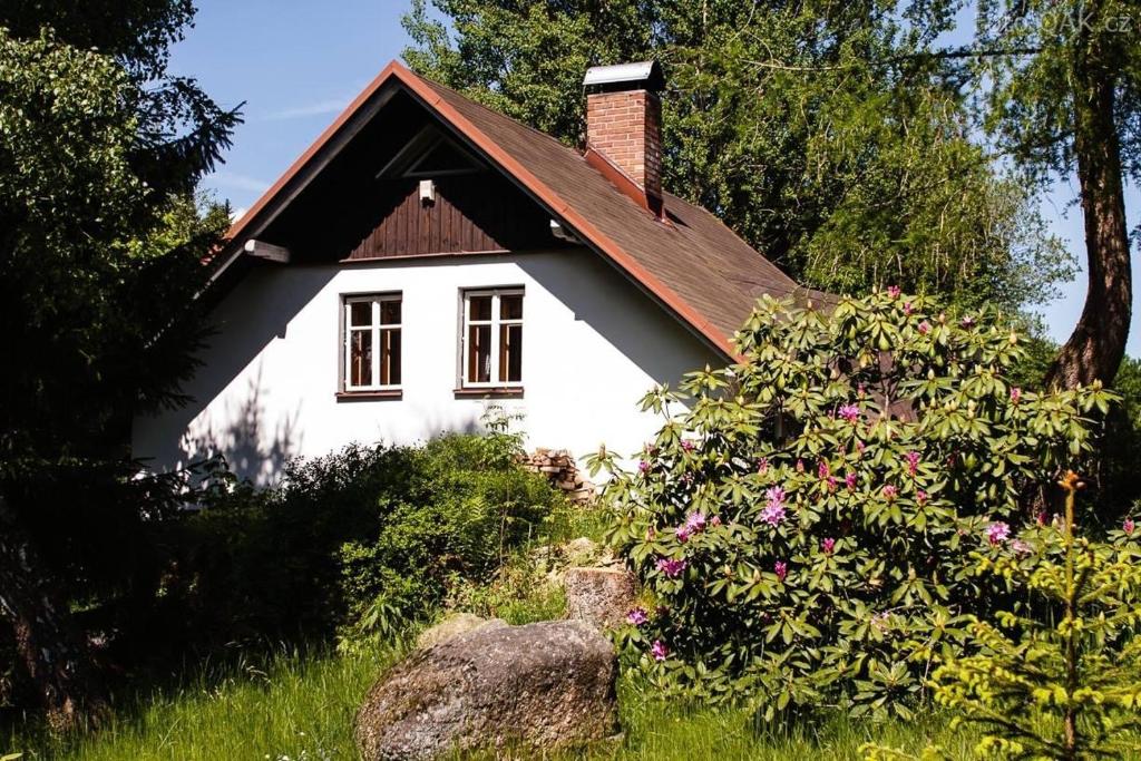 Lučany nad NisouChata Sedmidomí的一间白色的小房子,有红色的屋顶