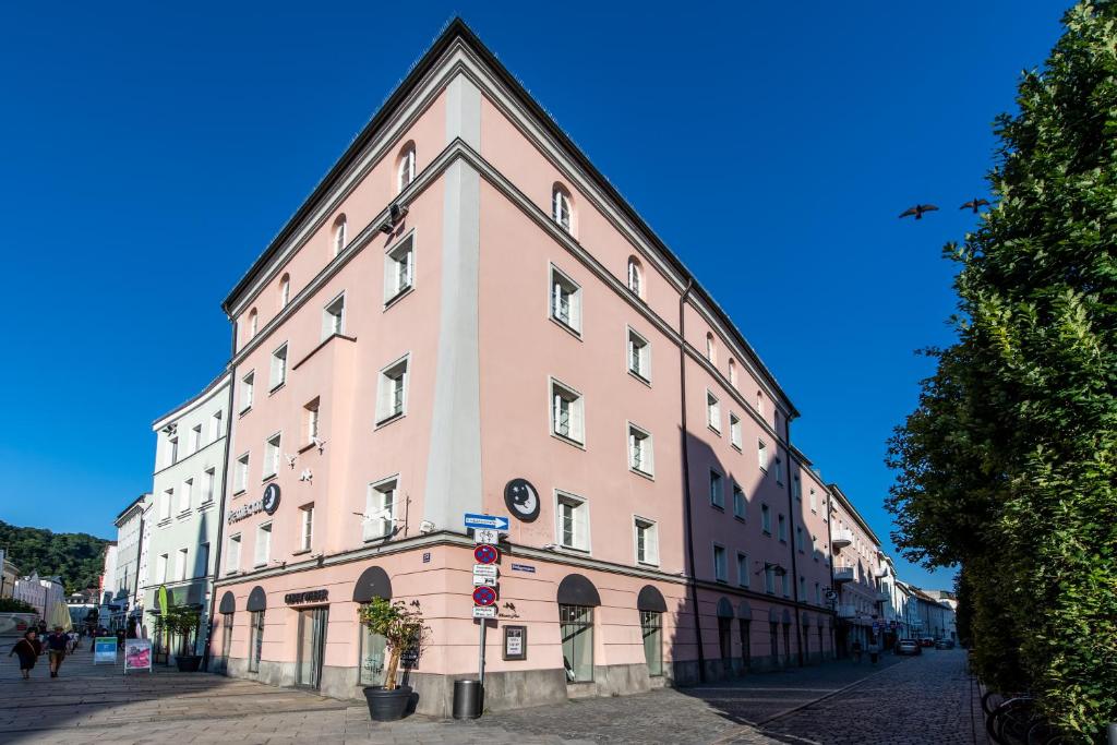 帕绍Premier Inn Passau Weisser Hase的街道边的一座粉红色大建筑
