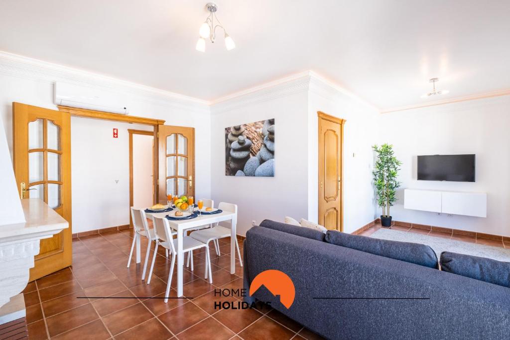 阿尔布费拉#020 Olhos d'Água with Shared Pool, Heated Floor的客厅配有蓝色的沙发和桌子