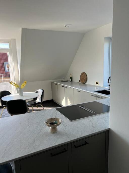 夏洛滕隆Designer apartment的厨房配有柜台和桌椅