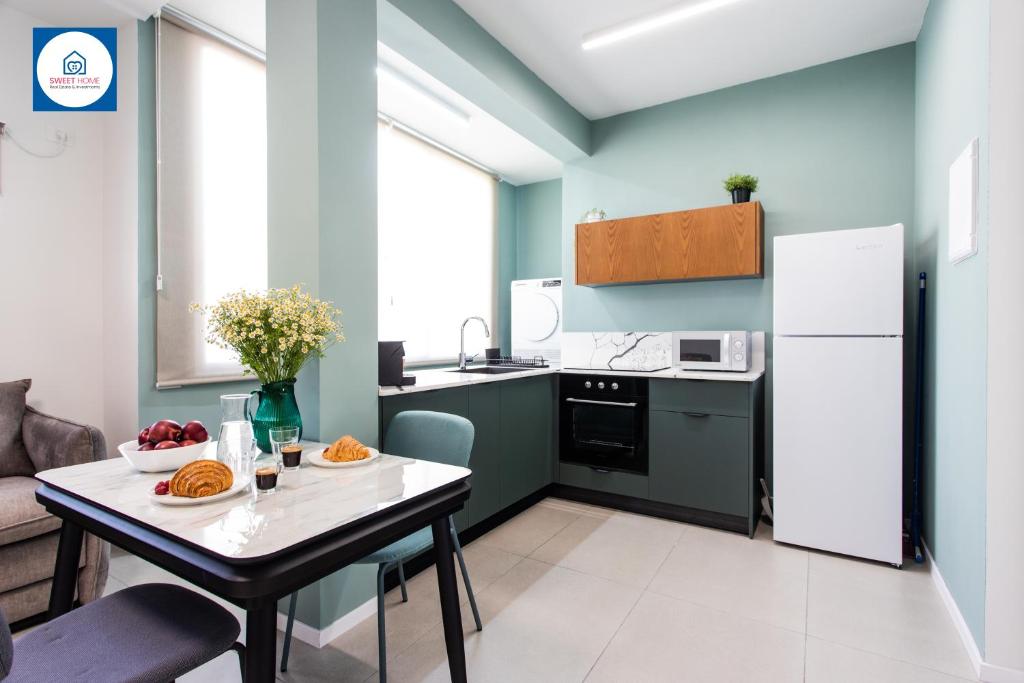 内坦亚Design apartments in Netanya的厨房配有桌子和白色冰箱。