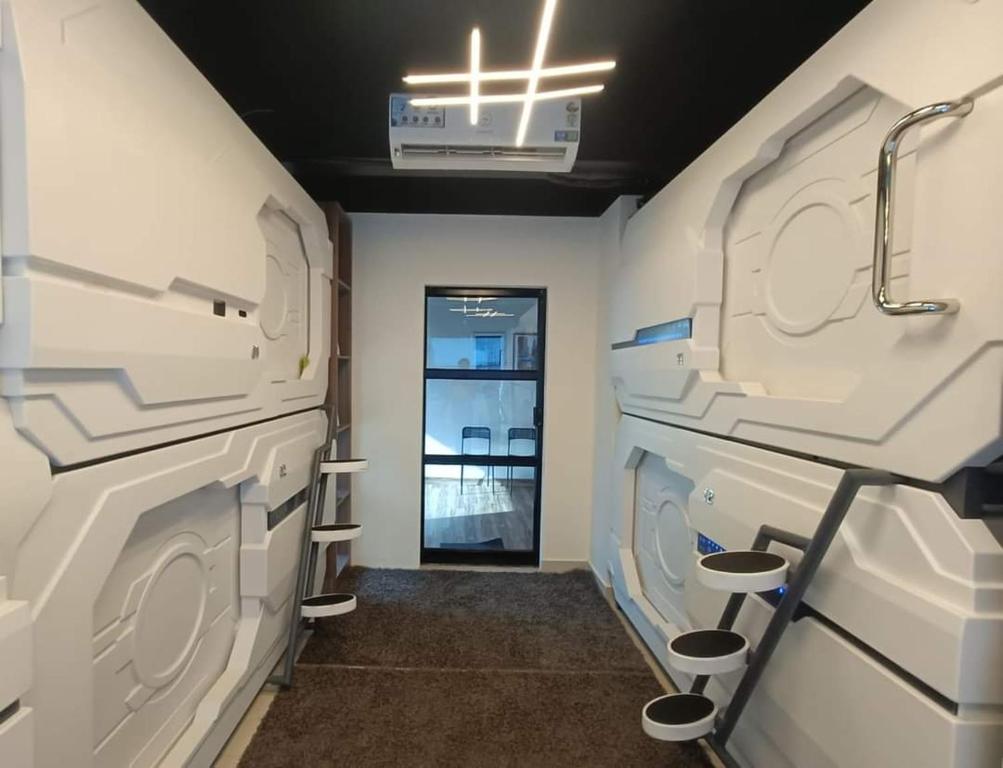 特里凡得琅TRIVPODS Capsule Hotel的洗衣房配有白色洗衣机和烘干机