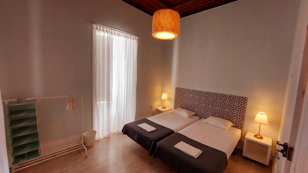 法鲁Hostel A Casa da Árvore的一间卧室设有一张大床和一个大窗户