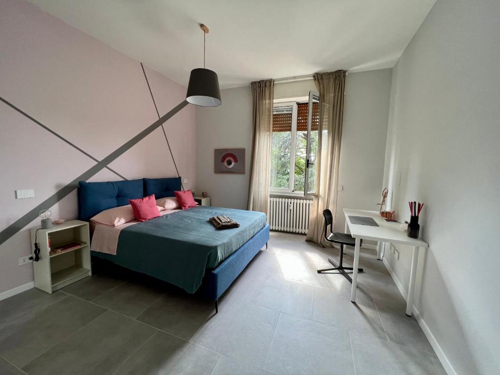 帕尔马Rosa di Parma的一间卧室配有一张带粉色枕头的床和一张书桌