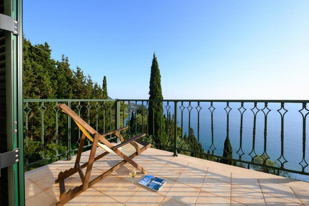 科孚镇Nisos Sunset Apartments Agios Gordios的俯瞰水面的阳台的木凳