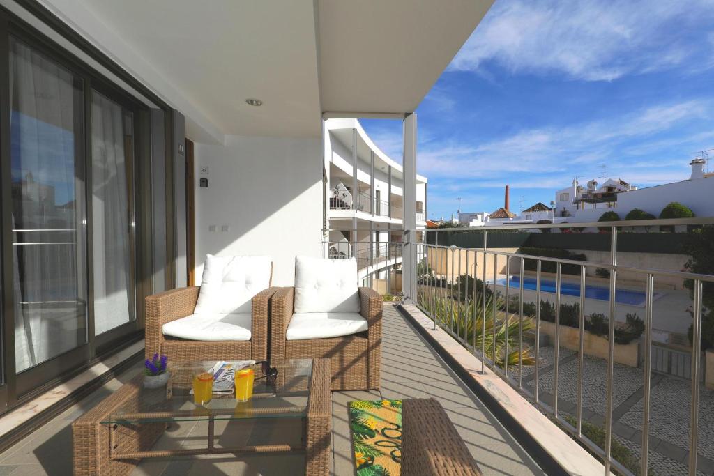 塔维拉Apartment Pepita-tavira Centre, Pool & Garage的大楼内的阳台配有两把椅子和一张桌子