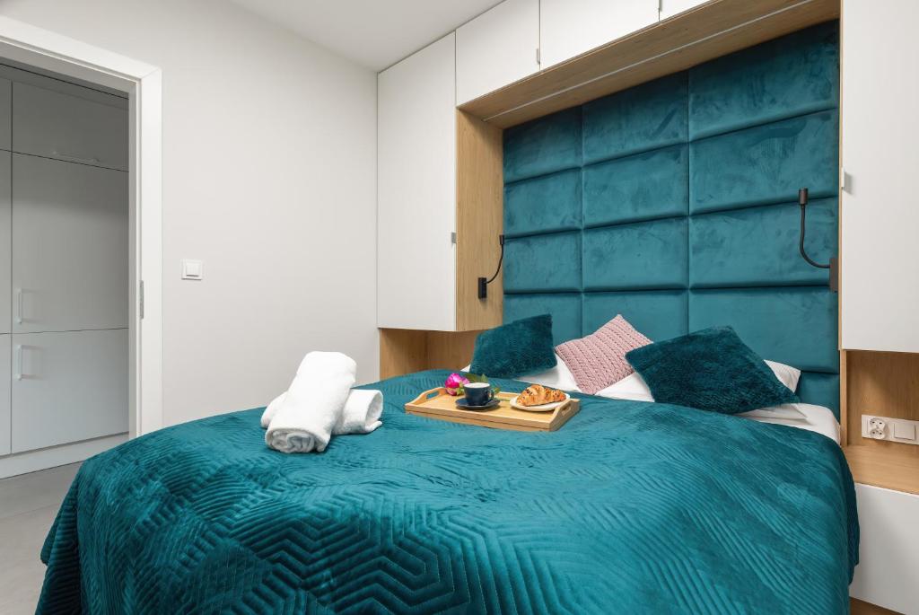 米泽德沃兹Luxurious Little Laguna Apartments SPA & Gym by Renters Prestige的一间卧室配有一张蓝色的床,上面有托盘