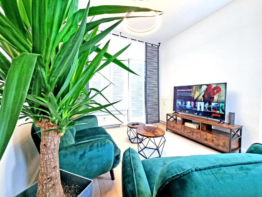 莱比锡HappySide - iNDUSTRiAL DESiGN - KÜCHE - CiTY NAH -的客厅配有蓝色沙发和植物