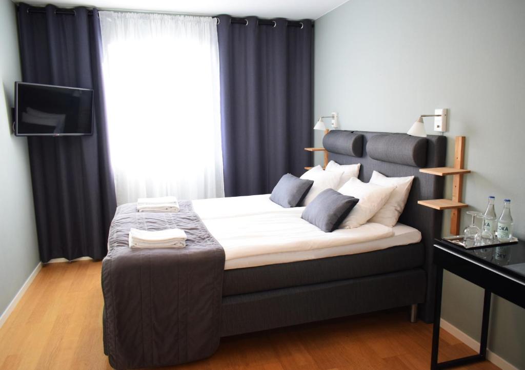 TierpGästis Tierp的一间卧室配有一张大床和黑色床头板