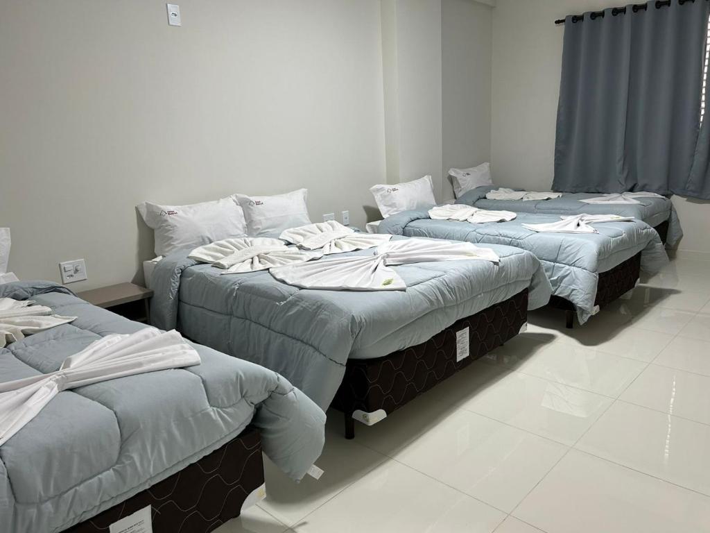 阿帕雷西达Hotel Beirut的一间设有三张床的客房,备有毛巾