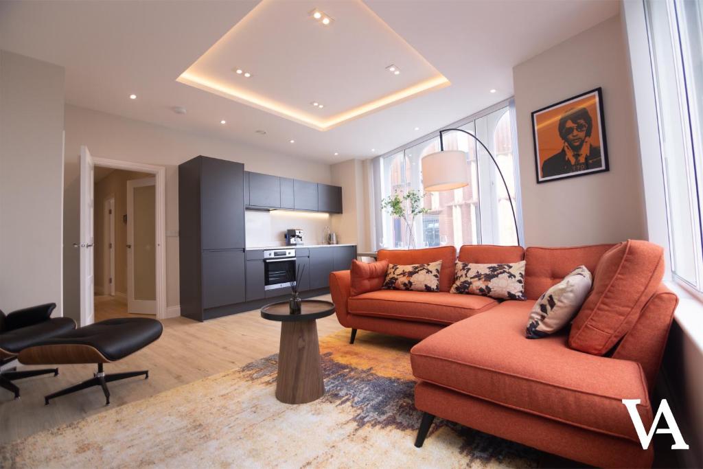 利兹Velvet Apartments - 56 Vicar Lane的一间带橙色家具的客厅和厨房
