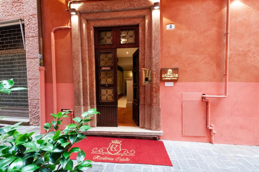 维罗纳Residenza Catullo - Apartments的前方有红色地毯的建筑的门
