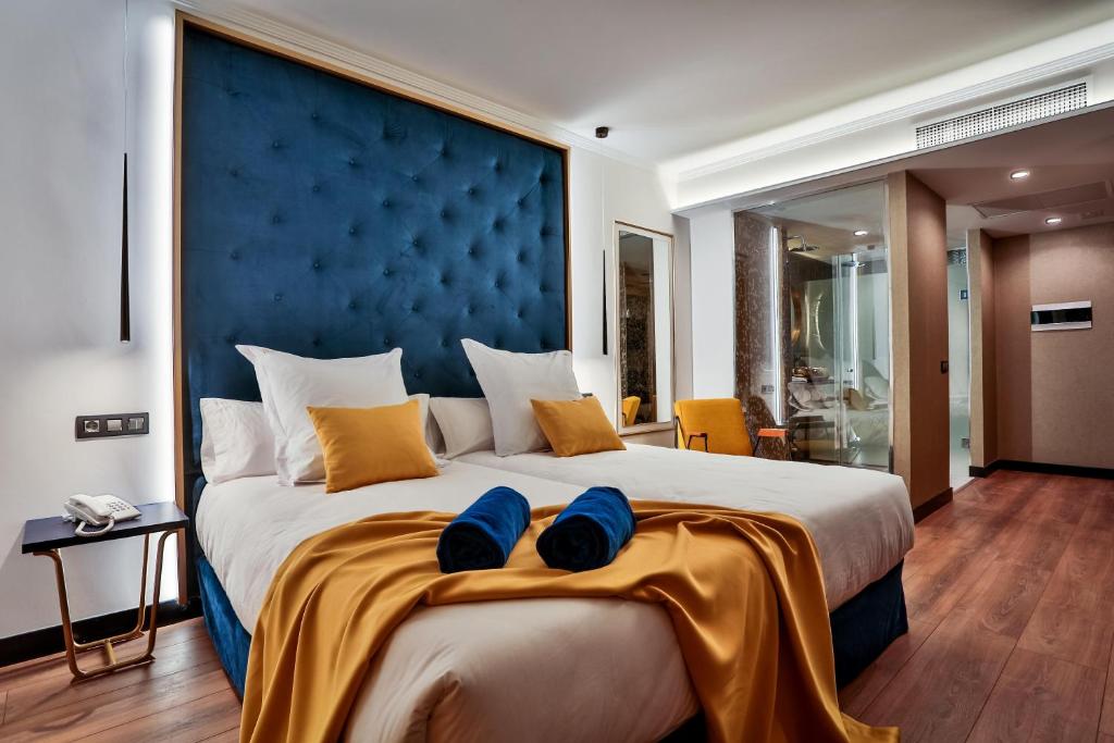 大加那利岛拉斯帕尔马斯Design Plus Bex Hotel的一间卧室配有一张带蓝色床头板的大床