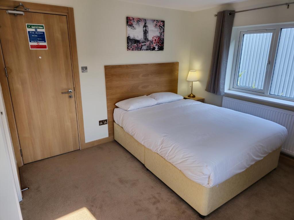 伦敦Homefield Lodge的一间卧室设有一张大床和一扇木门